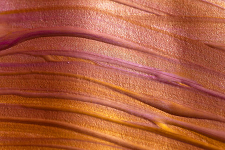 Colored background from mixed acrylic paints of gold and pink colors. Artistic concept