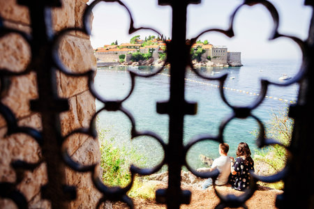 Girl looks at the island of St. Stephen sitting on the edge of the mountain. view through the vintage latticeの写真素材