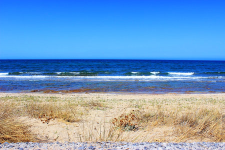 View of the sea and rocky shore in calm hot weather, the sea is calm, relax blueの写真素材