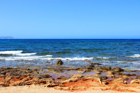 View of the sea and rocky shore in calm hot weather, the sea is calm, relax blueの写真素材