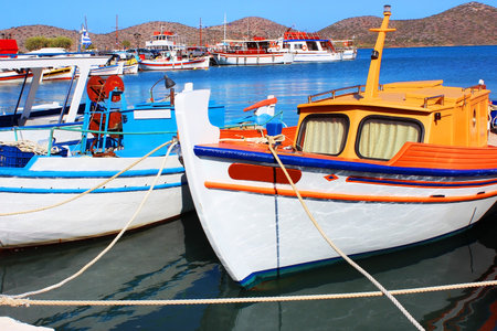Greek fishing boats are moored at city port.の写真素材