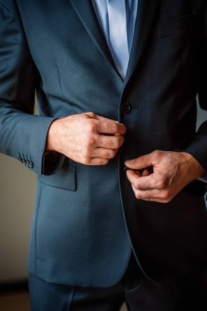  Elegant man s hands in black suit buttoning upの写真素材