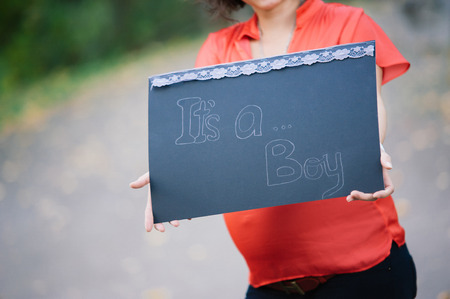 Young pregnant woman holding a signの写真素材