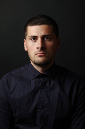 Serious looking man with dark shirt portraitの写真素材