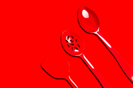 Plastic kitchen utensils on isolated on redの写真素材