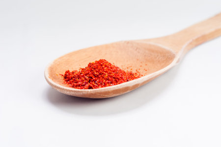 Sweet paprika dust Isolated on White Background in wooden spoonの写真素材