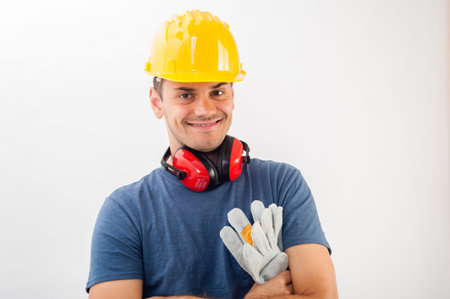 Workman wearing a yellow hard hat and full protective gear smiling at the camera .の写真素材