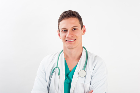 Medical portrait. Male nurse or young man doctor smiling happy and proud in blue scrubs isolated on white background. Young caucasian male medical professional.の写真素材