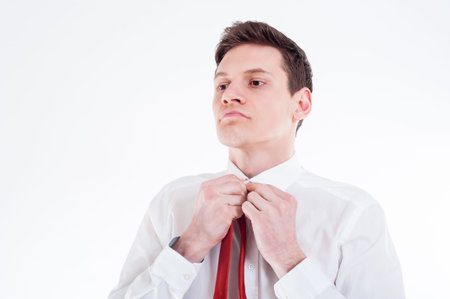 Young businessman tying a red tie
