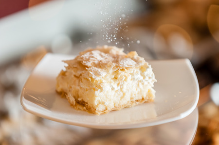 A fresh piece of coconut vanilla cream cake on a white plateの写真素材