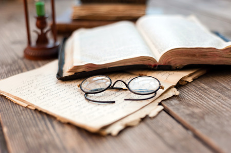 Vintage book, glasses and watches on the background of a wooden wall. Retro conceptの写真素材