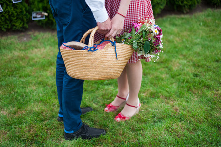 Couple in the grass, only legs, engagement photo, before wedding, picnic, sunny day, romantic photo, without face, girl with pin up dress, vintage colorの写真素材
