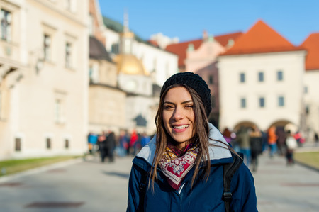 Young woman tourist in the city of Kracow , Poland, visiting the city and taking a picture in front of a famos church.の写真素材