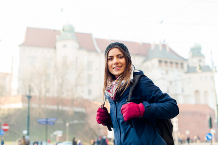 Young woman tourist in the city of Kracow , Poland, visiting the city and taking a picture in front of a famos church.の写真素材