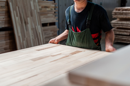 Man worker holding a big countertop in a furniture manufacture production.の写真素材