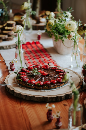 Sliced home made strawberry and chocolate pie on a wood board.の写真素材