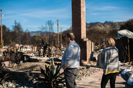Man and his wife owners, checking burned and ruined of their house and yard after fire, consequences of fire disaster accident. Ruins after fire disaster.の写真素材