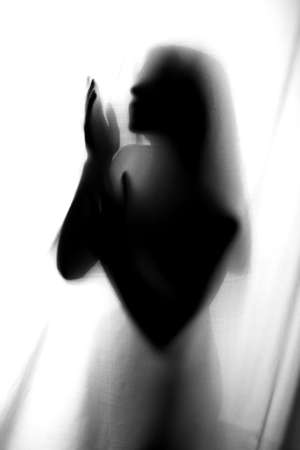 Silhouette of girl behind a curtain. Abstract and blurred image of a girlの写真素材