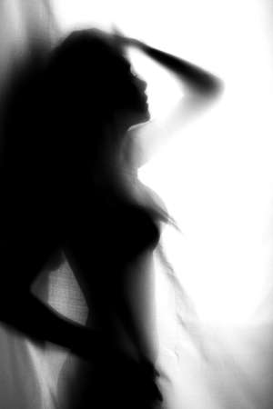 Silhouette of girl behind a curtain. Abstract and blurred image of a girlの写真素材