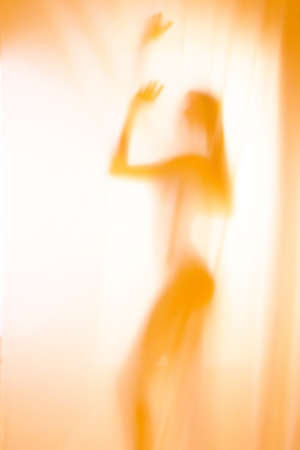 Silhouette of girl behind a curtain. Abstract and blurred image of a girlの写真素材