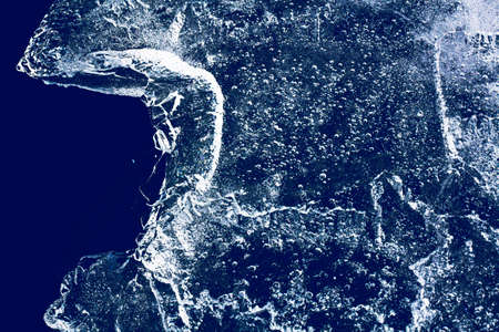 Ice texture with frozen bubbles and cracks on a dark blue background. Beautiful abstract decorative background. Stylish abstract design for wraps, gift, fabric, textile, furnishing. Winter pattern.の写真素材