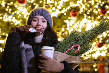 young beautiful happy Face of smiling girl posing. Christmas tree Happy New Year eating Chocolate with coffe cupの写真素材