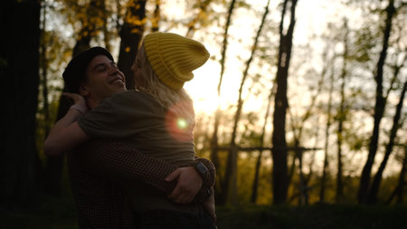 man and woman at sunset. A romantic date and love on nature of loving happy couple. Dancing and fooling couple in forest at sunsetの写真素材