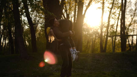 man and woman at sunset. A romantic date and love on nature of loving happy couple. Dancing and fooling couple in forest at sunsetの写真素材