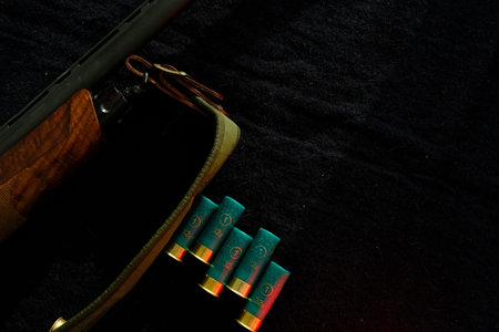 Weapon on black cloth: rifle, shells,top view. Top view of rifle, shells on black cloth background.
