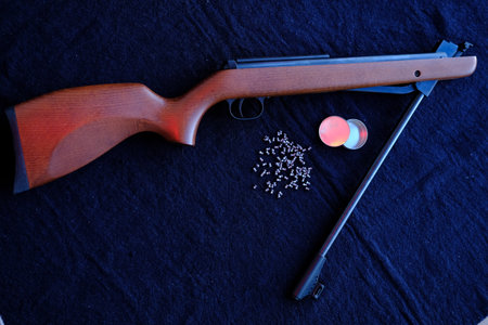 Rifle gun break in two with air pellets for hunting on cloth dark background.の写真素材