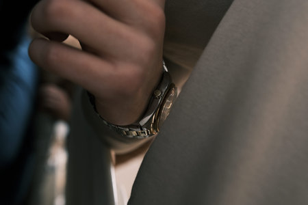 luxury watch on hand with selective focus calm tone on biege backgrond. concept for managing time...