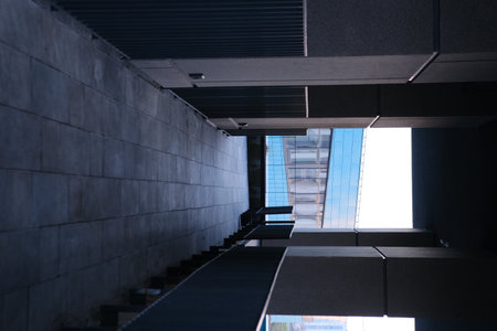 Long tunnel with columns and metal fance in modern city architecture with low lights and grey colors with tile on the frloorの写真素材