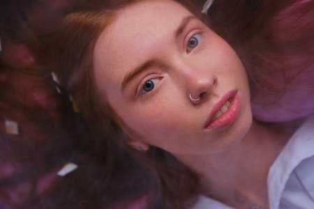 Young redhead Teenager Girl In the smoke with blue eyes and red hairs Relaxing On pink Bed At Home...