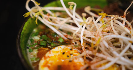 Delicious bowl of ramen, sprouted greens, seaweed, noodles, eggs, and forcemeat. Close-up shot captures the rich, nourishing soup, perfect for food enthusiasts seeking culinary inspiration.の写真素材