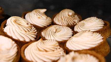 Creamy white tart with golden toasted top in shortcrust pastry on white plate in bakery display...