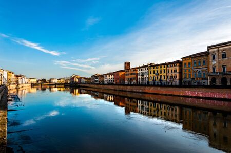 Pisa, Italy - Dec 29, 2017 - Beautiful reflections in the water of river in Pisa, with blue sky on the backgroundのeditorial素材