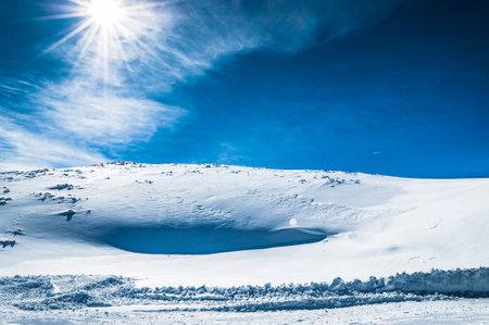 Snow mountain and clean blue sky with bright sun
