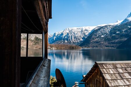 Snow covered Alps on the background of spectacular view from old wooden house on the border of mountain lakeの写真素材
