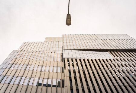 Bottom view of an old tall building and a street lampの写真素材