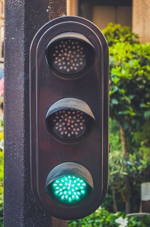 Green traffic light on the pillar up closeの写真素材