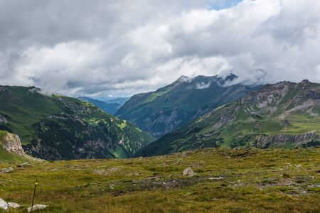 Green mountains under cloudy sky in the morningの写真素材