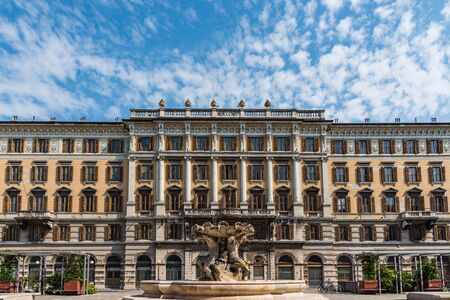 Ancient govermental building with multiple columns and windows during sunny day and blue cloudy sky on the backgroundの写真素材