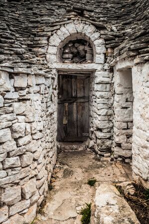 Old wooden door hidden between huge stone wallsの写真素材
