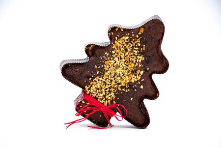 Red stripe on the gingerbread tree with nuts on the white backgroundの写真素材