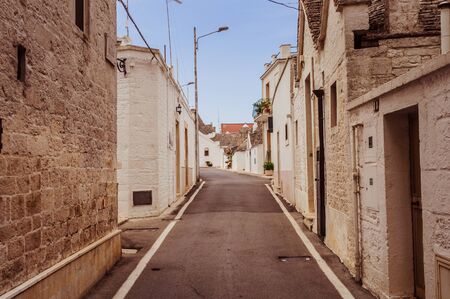 Old italian street surrounded by old buildings with balconies and with blue sky on the backgroundの写真素材