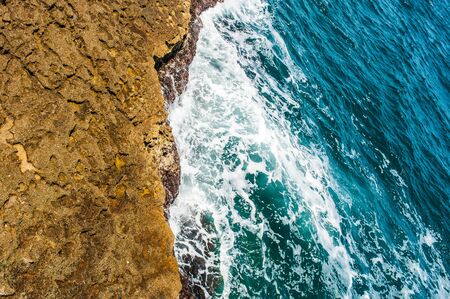Blue sea waves washing the rock on the close up shotの写真素材