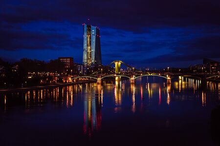 Evening sky over Frankfurt skyscrapers reflecting in the water of Mainの写真素材