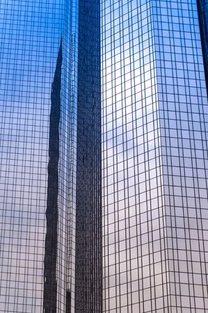 Modern glass office building close up with the sky reflectingの写真素材