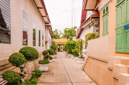 Narrow street between white houses in Bangkokの写真素材