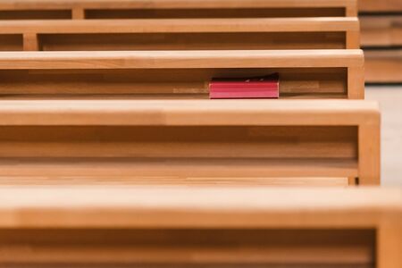Old hymnbook laying under the table for prayer in the churchの写真素材
